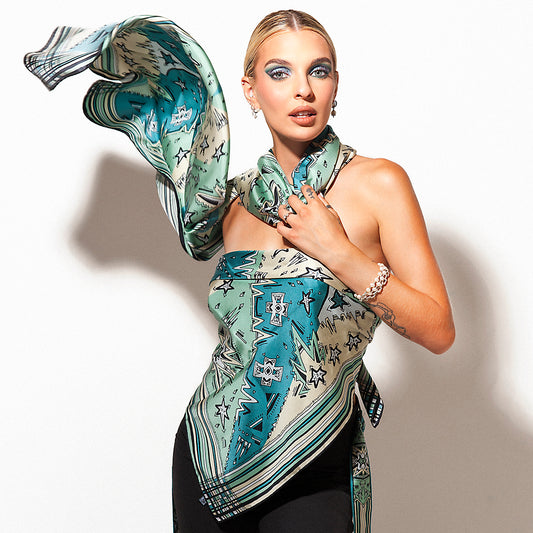 modella in posa vestita da foulard e stola turchesi e ottanio che volano con leggerezza