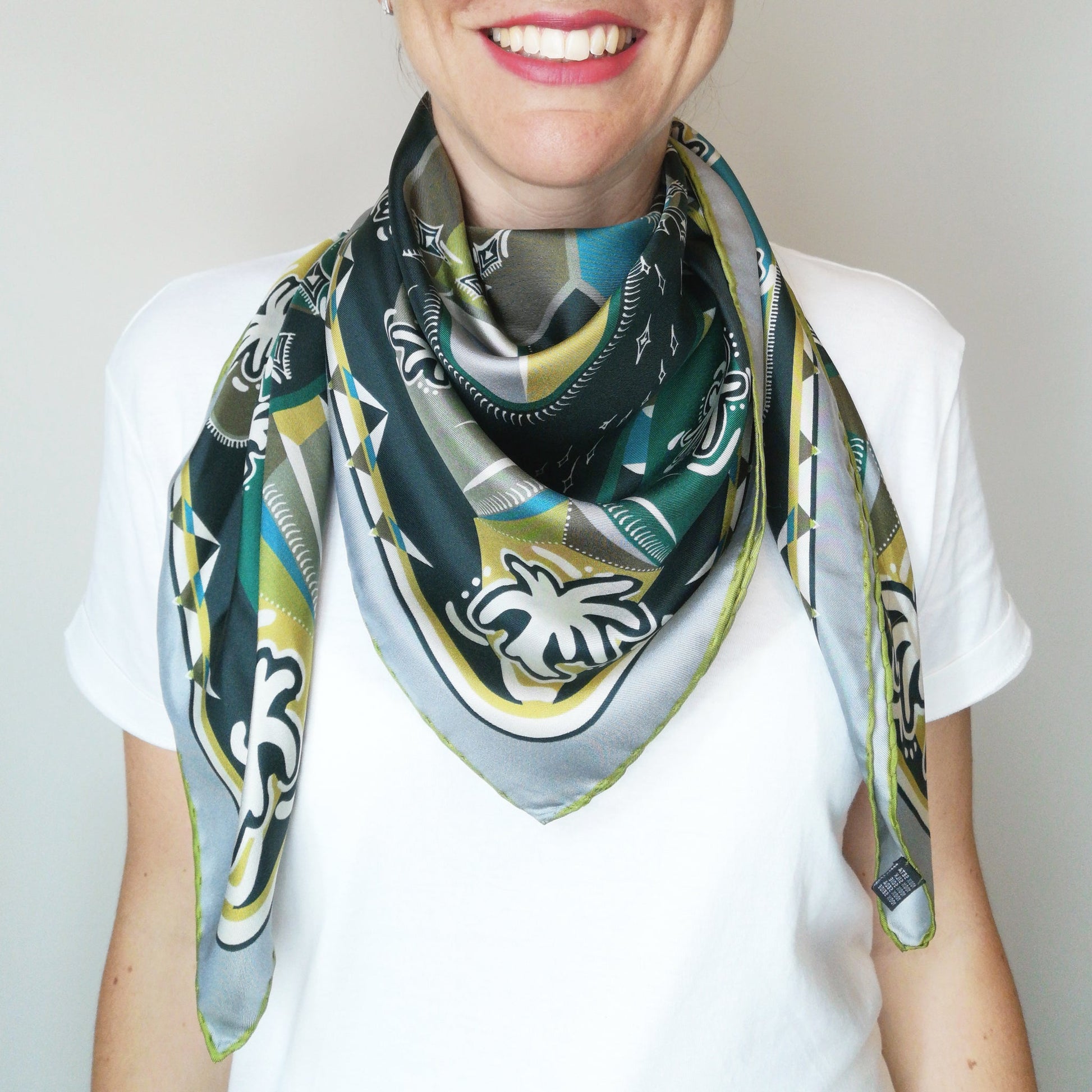 foulard carré variante verde con disegno tessile della natura e geometrie indossato stile western intorno al collo donna
