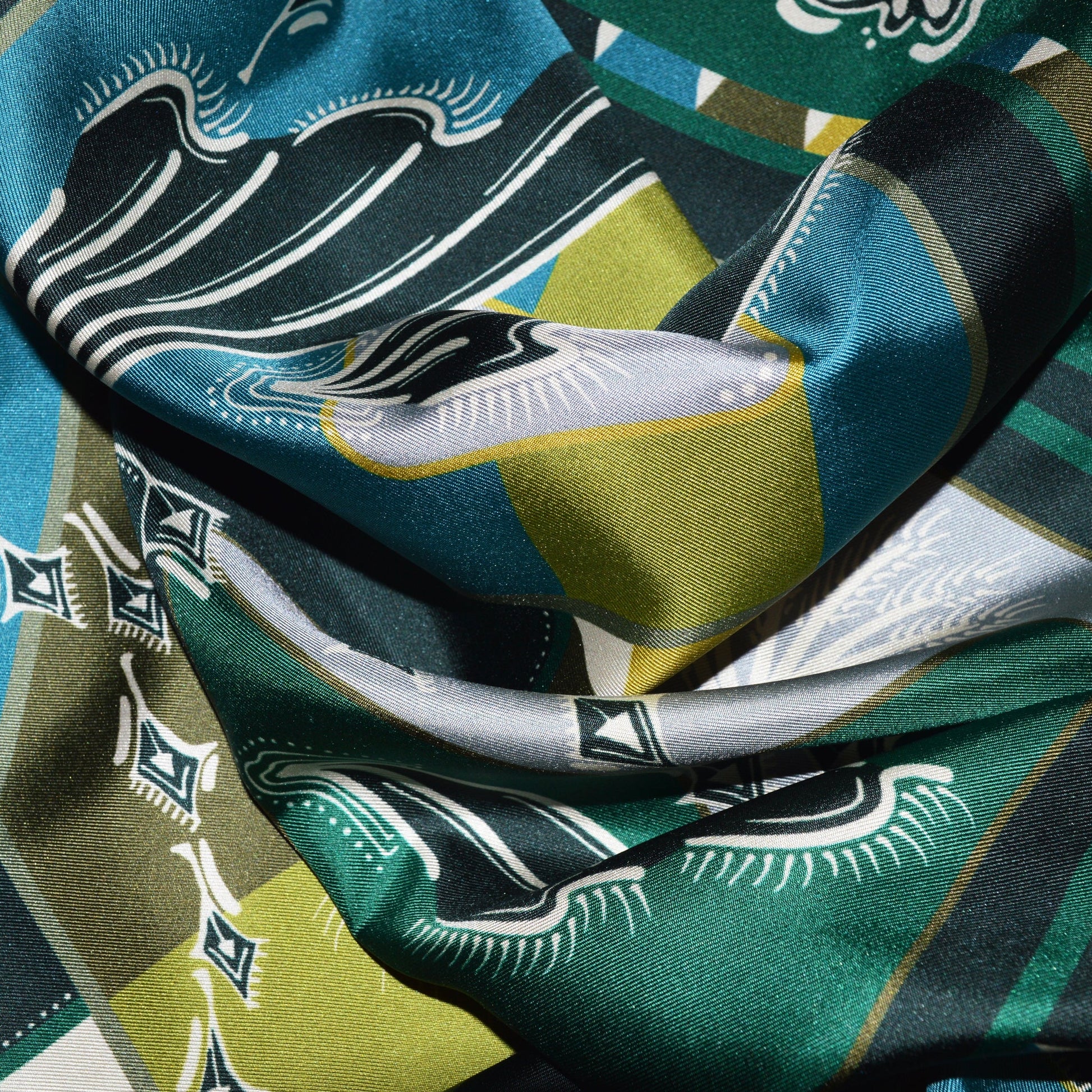 dettaglio ingrandito del tessuto lussuoso con stampa di fiori e ali colore avorio e mix di verdi