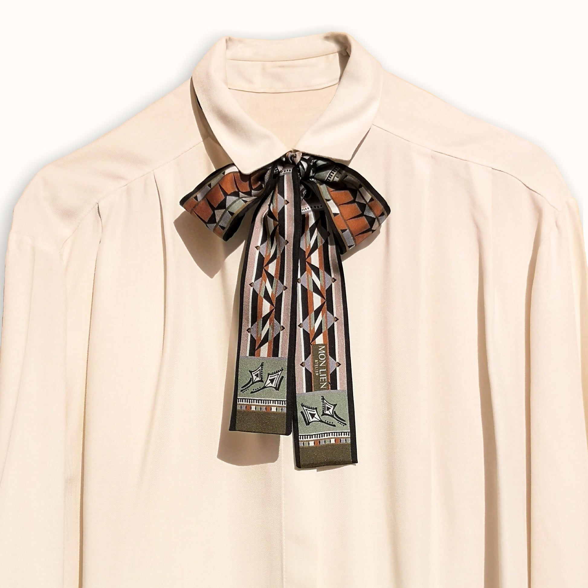 fusciacca in seta annodata intorno al collo di una camicia con un fiocco per un look raffinato