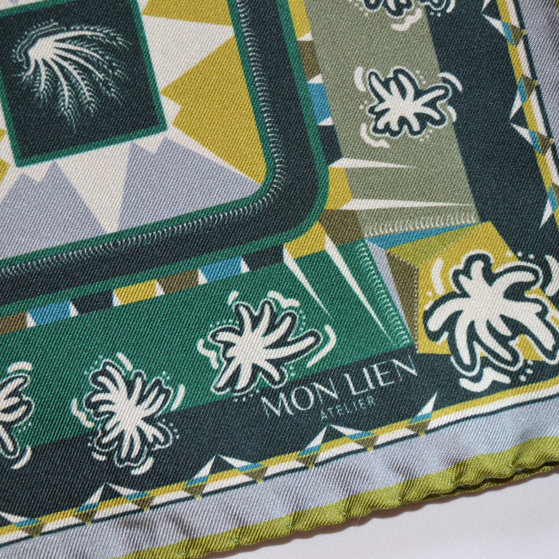 dettaglio ingrandito del fazzoletto da taschino con trame del tessuto e grafiche colorate logo non lien atelier e orlo a contrasto