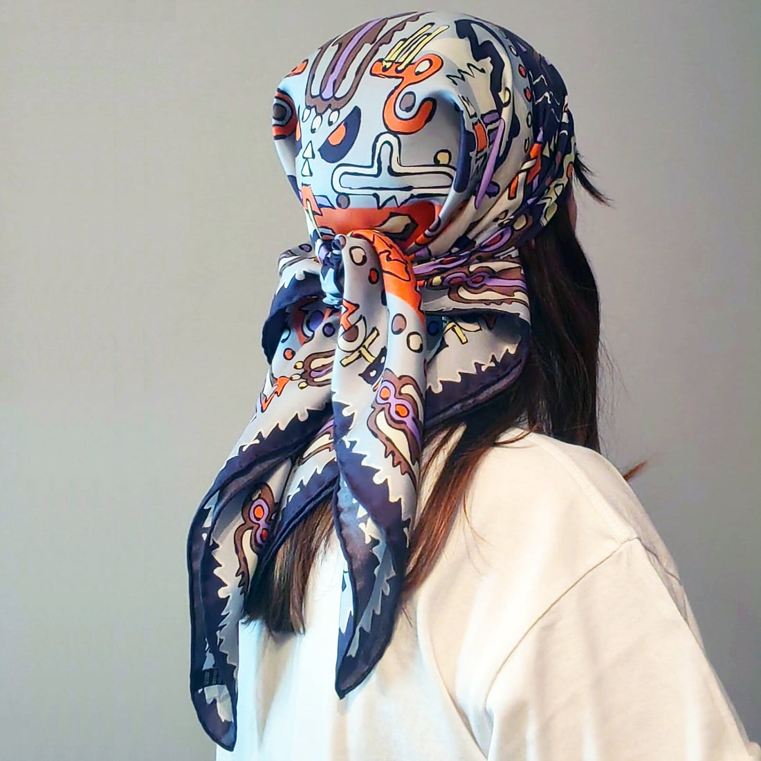 Foulard in seta colorato annodato in testa, donna stile sofisticato e contemporaneo