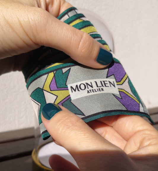 nastro in twill di seta stampata con logo Mon Lien Atelier tra le mani di una modella