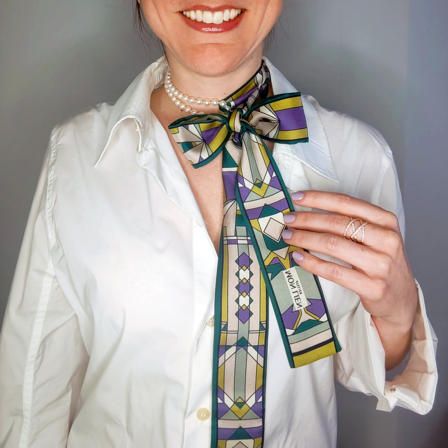 modella indossa twilly di seta stampata  insieme ad una collana di perle elegante