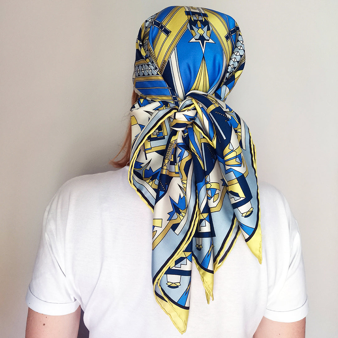 foulard in seta blu e giallo annodato in testa come bandana