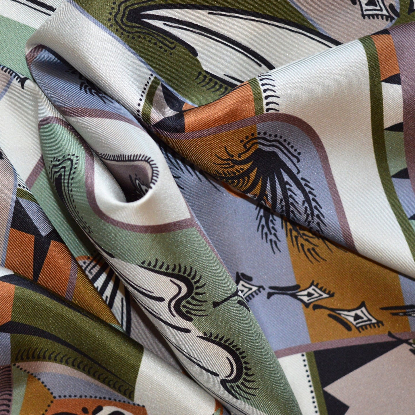 vista ingrandita di un particolare di foulard carré con pattern  di piante e bordo geometrico multicolor