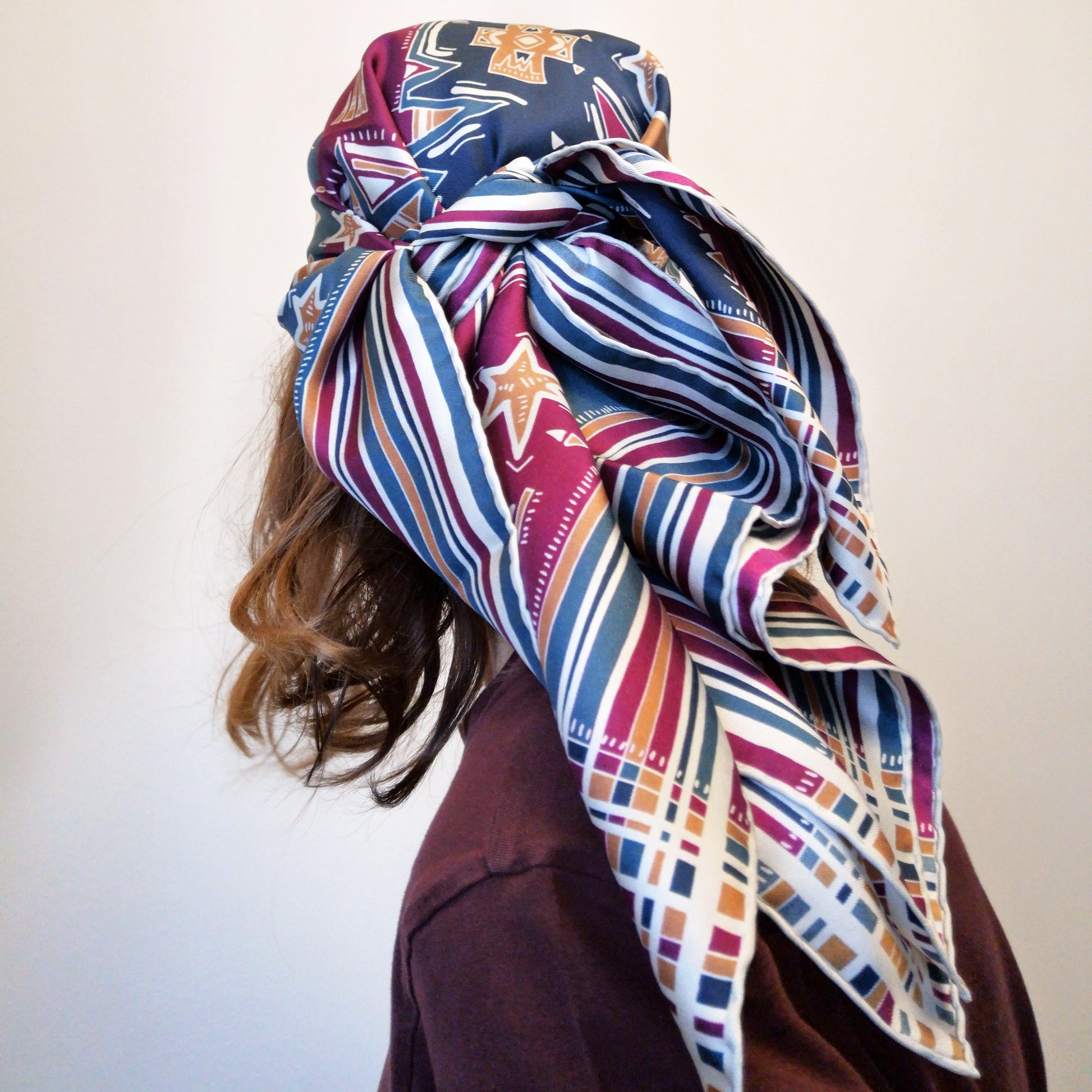 elegante foulard quadrato in seta stampata indossato in testa tramite un nodo colori bordeaux blu