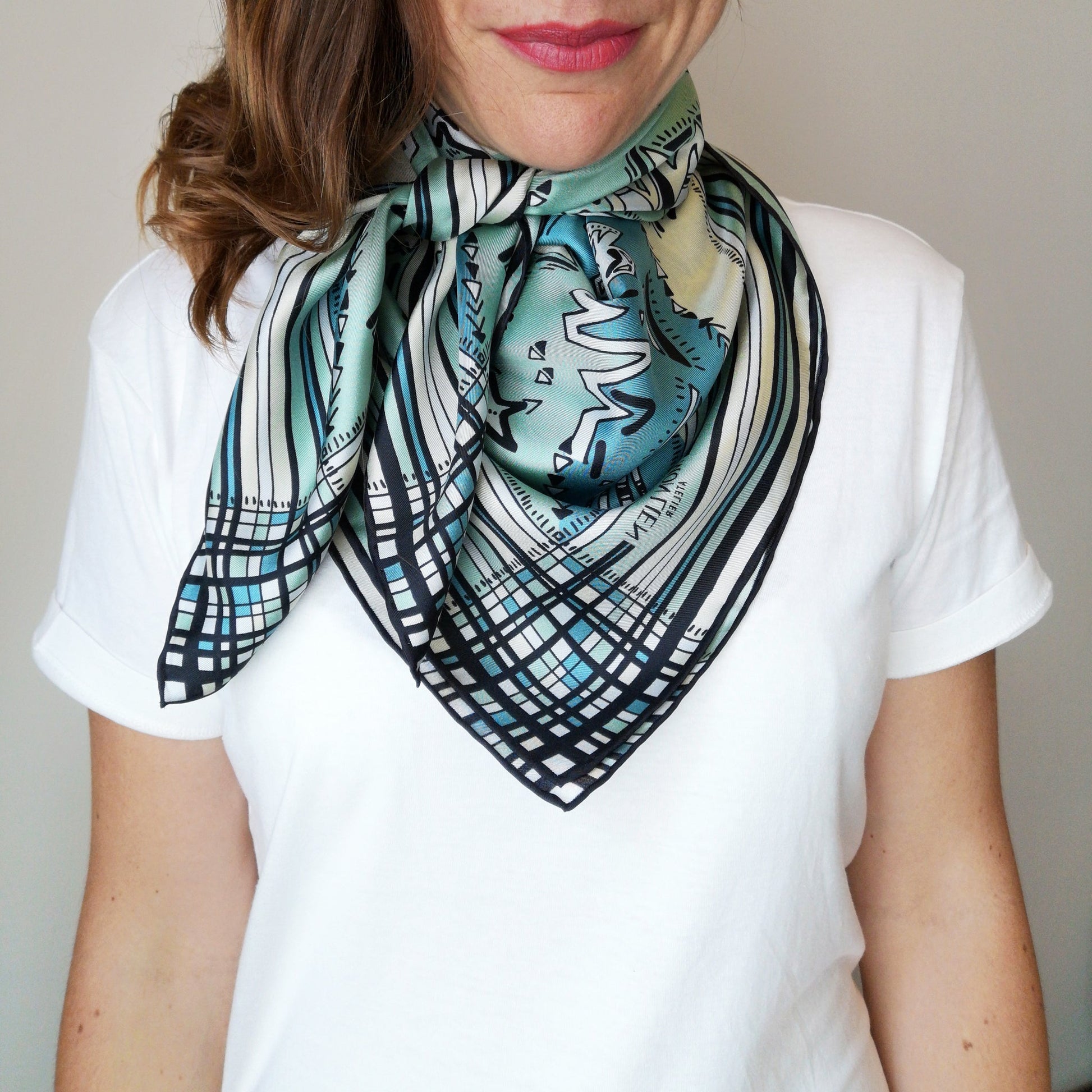 accessorio creativo in seta nelle nuance chiare indossato intorno al collo con maglietta bianca